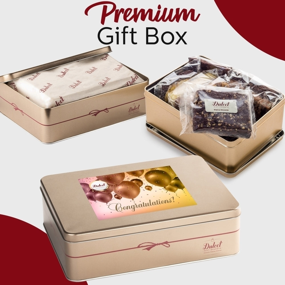 Dulcet gold congratulations gift tin showcasing individually wrapped gourmet brownies, branded tissue paper, and a celebratory lid featuring gold and pink balloons.