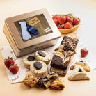 Dulcet gold Father's Day gift tin featuring a blue necktie greeting design, surrounded by chocolate brownies, blondies, chocolate-topped cookies, hamantaschen, rugelach and strawberries.