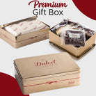 Dulcet premium gold gift tin shown open and closed, featuring elegant branded packaging, protective wrapping and individually wrapped gourmet brownies and bakery treats.