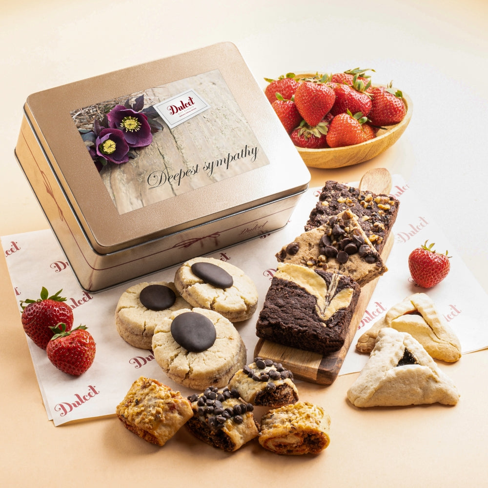 Dulcet sympathy gift tin with a Deepest Sympathy label, surrounded by assorted gourmet cookies, chocolate brownies, rugelach and pastries.