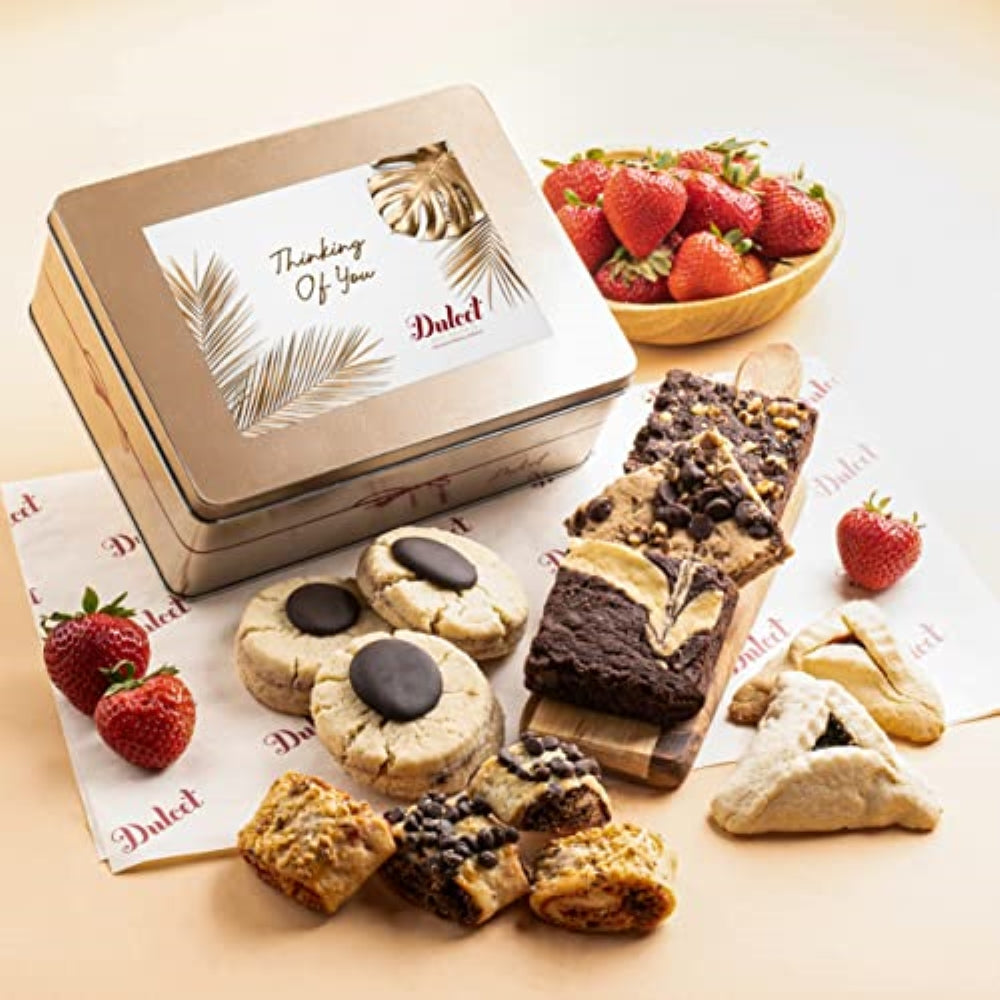 Dulcet Thinking of You gift tin with assorted brownies, chocolate cookies, rugelach and pastries, displayed alongside fresh strawberries.