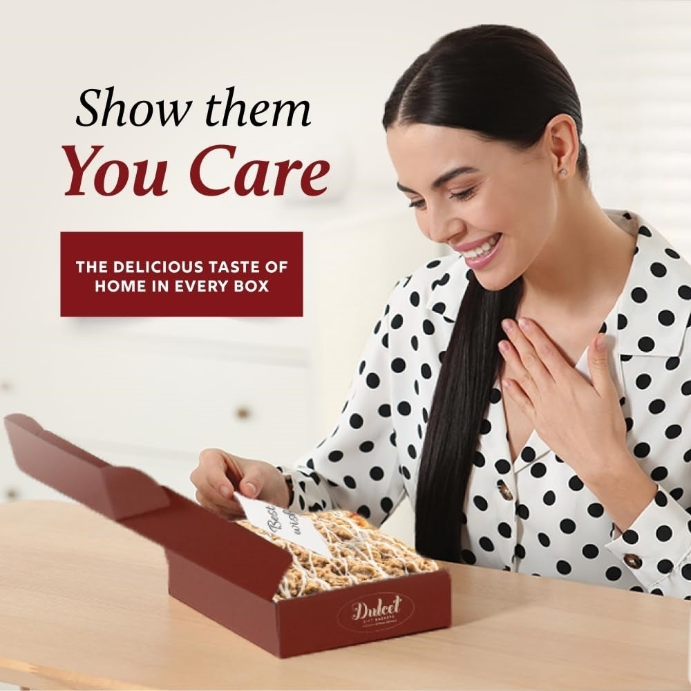Smiling woman opening a burgundy Dulcet gift box filled with drizzled bakery treats and a personalized note, highlighting thoughtful gifting.