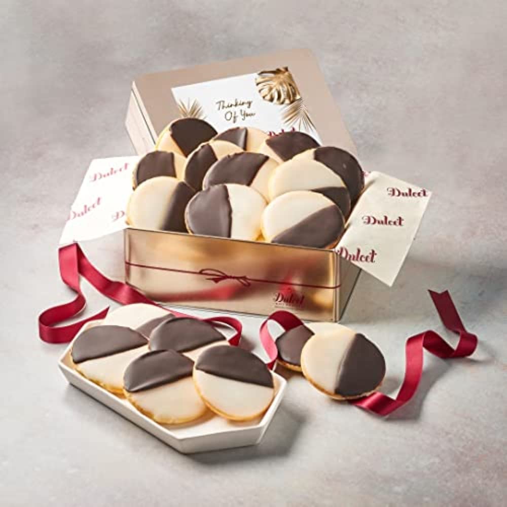 Black and white cookies displayed in a Dulcet gold Thinking of You gift tin with a leaf-design lid, red ribbon and serving tray.